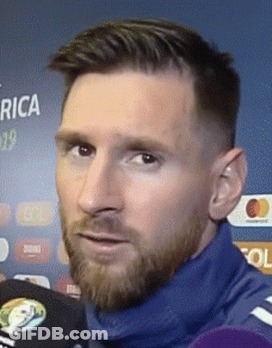 A Close Up Of A Man 'S Face With A Beard Wearing A Blue Sweater . GIF