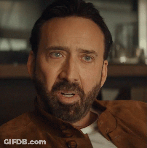A Close Up Of A Man 'S Face With A Beard Wearing A Brown Jacket GIF