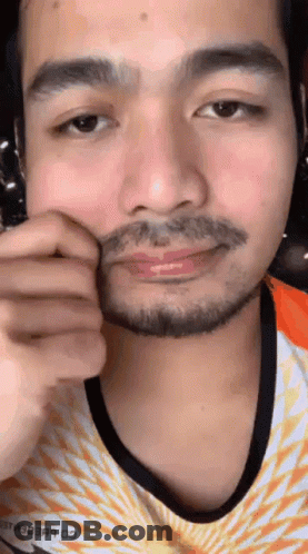 A Close Up Of A Man 'S Face With A Beard Wearing A Nike Shirt GIF