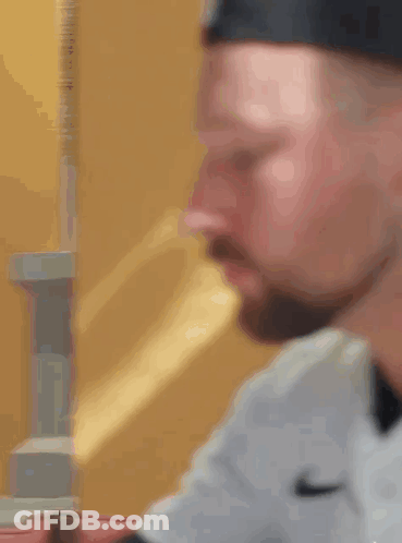 A Close Up Of A Man 'S Face With A Beard Wearing A Nike Shirt GIF