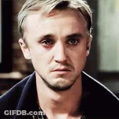 A Close Up Of A Man 'S Face With A Beard Wearing A Plaid Shirt And A Blue Jacket . GIF