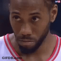 A Close Up Of A Man 'S Face With A Beard Wearing A Red And White Shirt . GIF