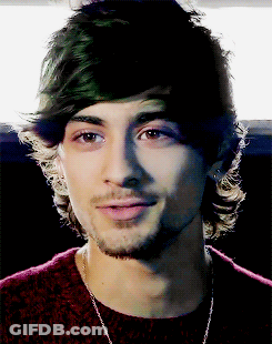 A Close Up Of A Man 'S Face With A Beard Wearing A Red Sweater GIF