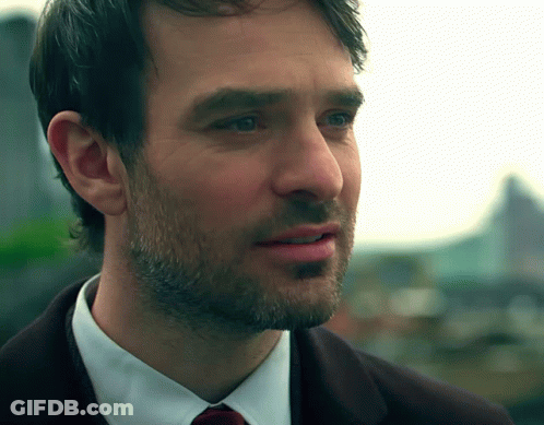 A Close Up Of A Man 'S Face With A Beard Wearing A Suit And Tie GIF