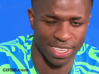 A Close Up Of A Man 'S Face With A Blue And Green Shirt On GIF