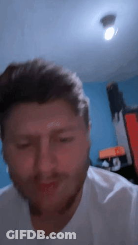 A Close Up Of A Man 'S Face With A Blue Background GIF