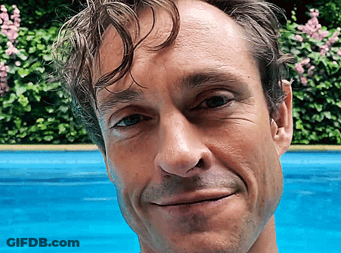 A Close Up Of A Man 'S Face With A Blue Background GIF