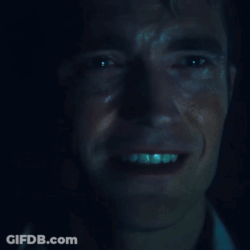 A Close Up Of A Man 'S Face With A Blue Light Shining On It GIF