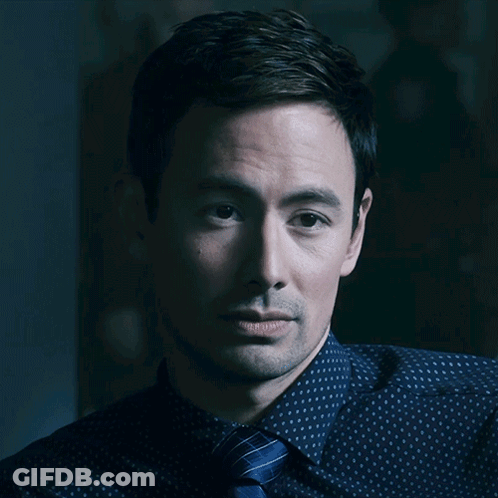 A Close Up Of A Man 'S Face With A Blue Shirt And Tie GIF