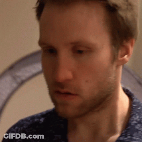 A Close Up Of A Man 'S Face With A Blue Shirt GIF