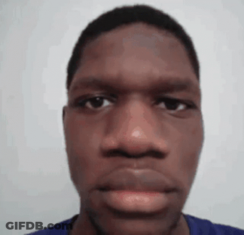 A Close Up Of A Man 'S Face With A Blue Shirt On Against A White Background . GIF