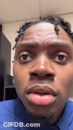 A Close Up Of A Man 'S Face With A Blue Shirt On GIF