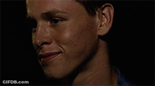 A Close Up Of A Man 'S Face With A Blue Shirt On GIF