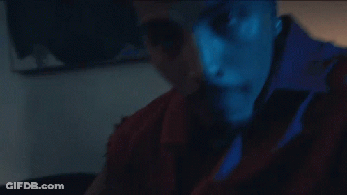 A Close Up Of A Man 'S Face With A Blue Shirt That Says ' A ' On It GIF
