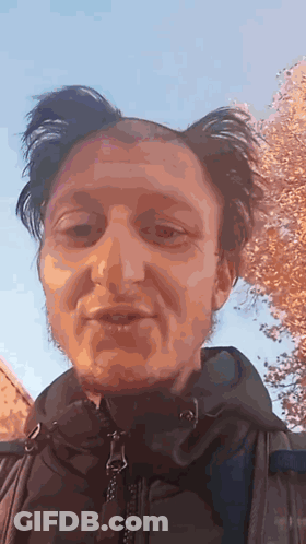 A Close Up Of A Man 'S Face With A Blue Sky In The Background . GIF