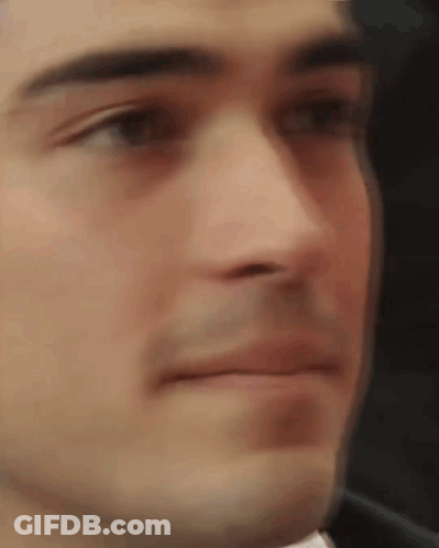 A Close Up Of A Man 'S Face With A Blurred Background Making A Funny Face . GIF