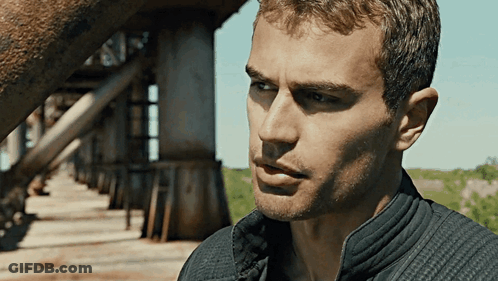A Close Up Of A Man 'S Face With A Bridge Behind Him GIF
