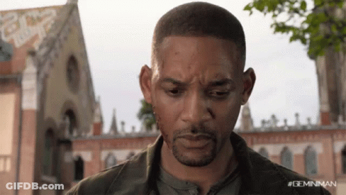 A Close Up Of A Man 'S Face With A Building In The Background GIF