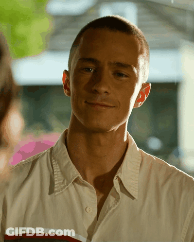 A Close Up Of A Man 'S Face With A Button Down Shirt GIF