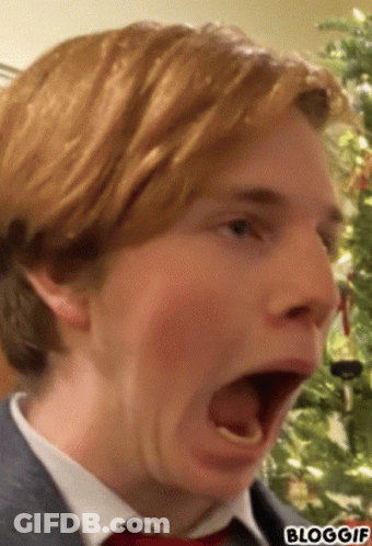 A Close Up Of A Man 'S Face With A Christmas Tree In The Background And The Words Bloggif Below It GIF