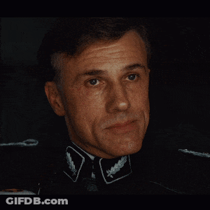 A Close Up Of A Man 'S Face With A Collar That Has A Leaf On It GIF
