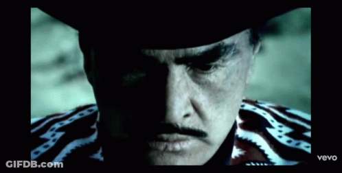 A Close Up Of A Man 'S Face With A Cowboy Hat And A Mustache . GIF