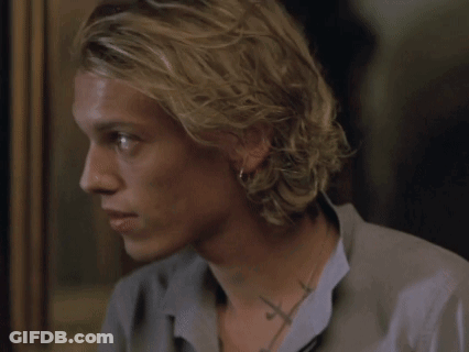 A Close Up Of A Man 'S Face With A Cross Tattoo On His Neck GIF