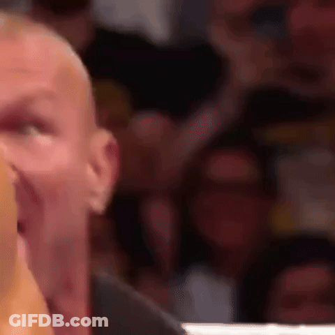 A Close Up Of A Man 'S Face With A Crowd Behind Him . GIF