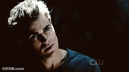 A Close Up Of A Man 'S Face With A Cw Logo Behind Him GIF