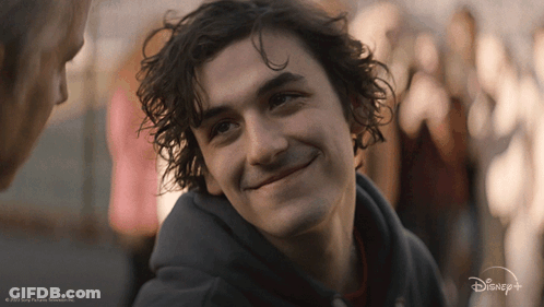 A Close Up Of A Man 'S Face With A Disney Logo Behind Him GIF