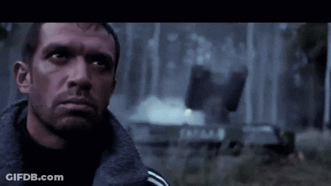 A Close Up Of A Man 'S Face With A Fire Behind Him GIF