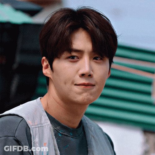 A Close Up Of A Man 'S Face With A Gray Shirt And A White Vest GIF