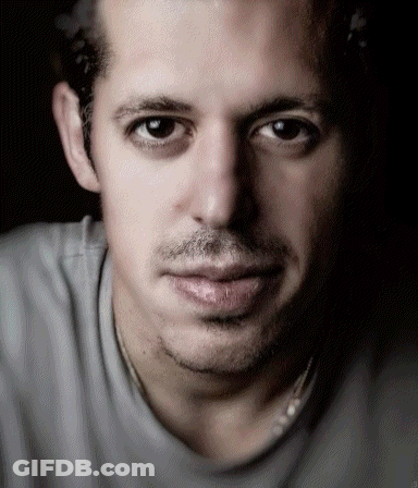 A Close Up Of A Man 'S Face With A Gray Shirt GIF