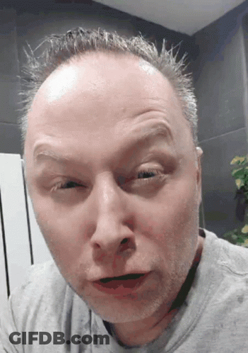 A Close Up Of A Man 'S Face With A Gray Shirt GIF
