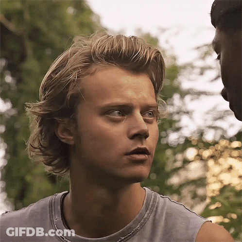 A Close Up Of A Man 'S Face With A Gray Tank Top On . GIF