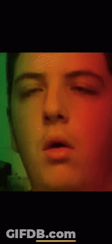 A Close Up Of A Man 'S Face With A Green Background GIF