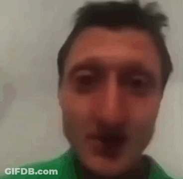 A Close Up Of A Man 'S Face With A Green Shirt On . GIF