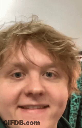 A Close Up Of A Man 'S Face With A Green Shirt On GIF