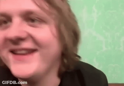 A Close Up Of A Man 'S Face With A Green Wall In The Background . GIF