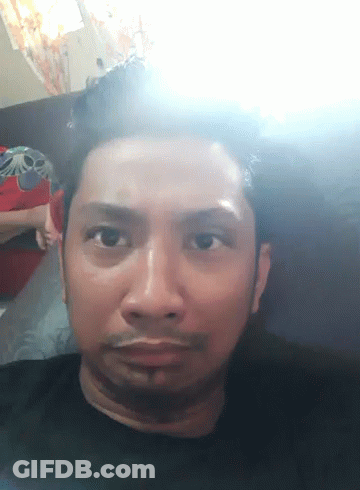 A Close Up Of A Man 'S Face With A Light Shining On It GIF