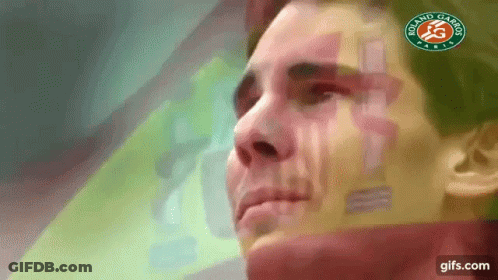 A Close Up Of A Man 'S Face With A Logo On His Shirt . GIF