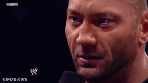 A Close Up Of A Man 'S Face With A Microphone In Front Of Him And A W Logo In The Background . GIF
