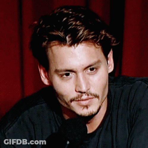 A Close Up Of A Man 'S Face With A Microphone GIF