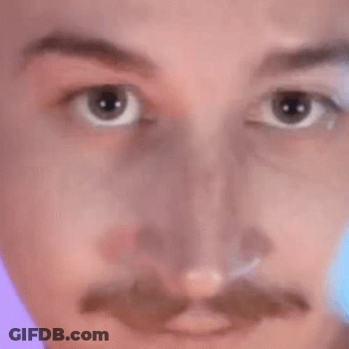 A Close Up Of A Man 'S Face With A Mustache And A Purple Background . GIF