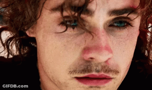A Close Up Of A Man 'S Face With A Mustache And A Red Nose . GIF