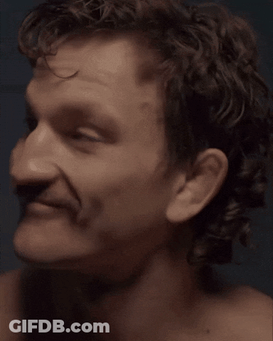 A Close Up Of A Man 'S Face With A Mustache And Curly Hair GIF