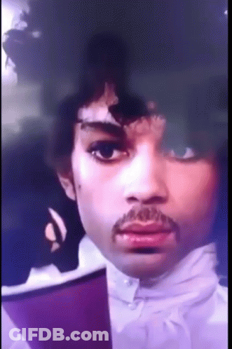 A Close Up Of A Man 'S Face With A Mustache And Purple Hair GIF