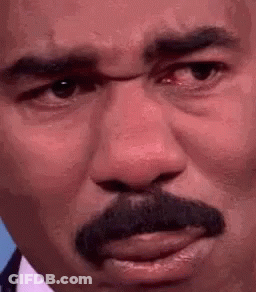A Close Up Of A Man 'S Face With A Mustache And Red Eyes . GIF