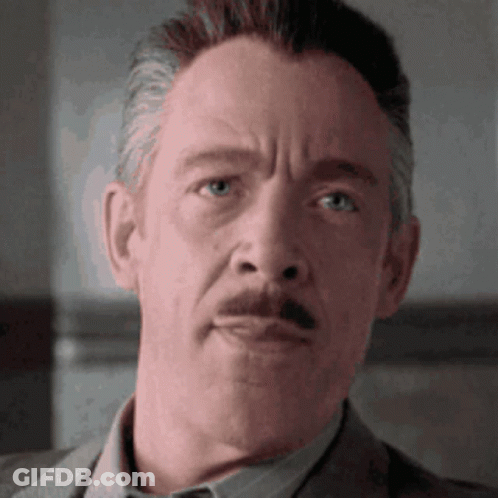 A Close Up Of A Man 'S Face With A Mustache Wearing A Suit GIF