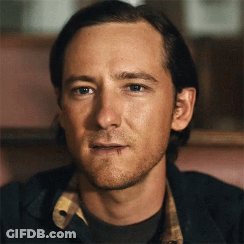 A Close Up Of A Man 'S Face With A Plaid Shirt On GIF
